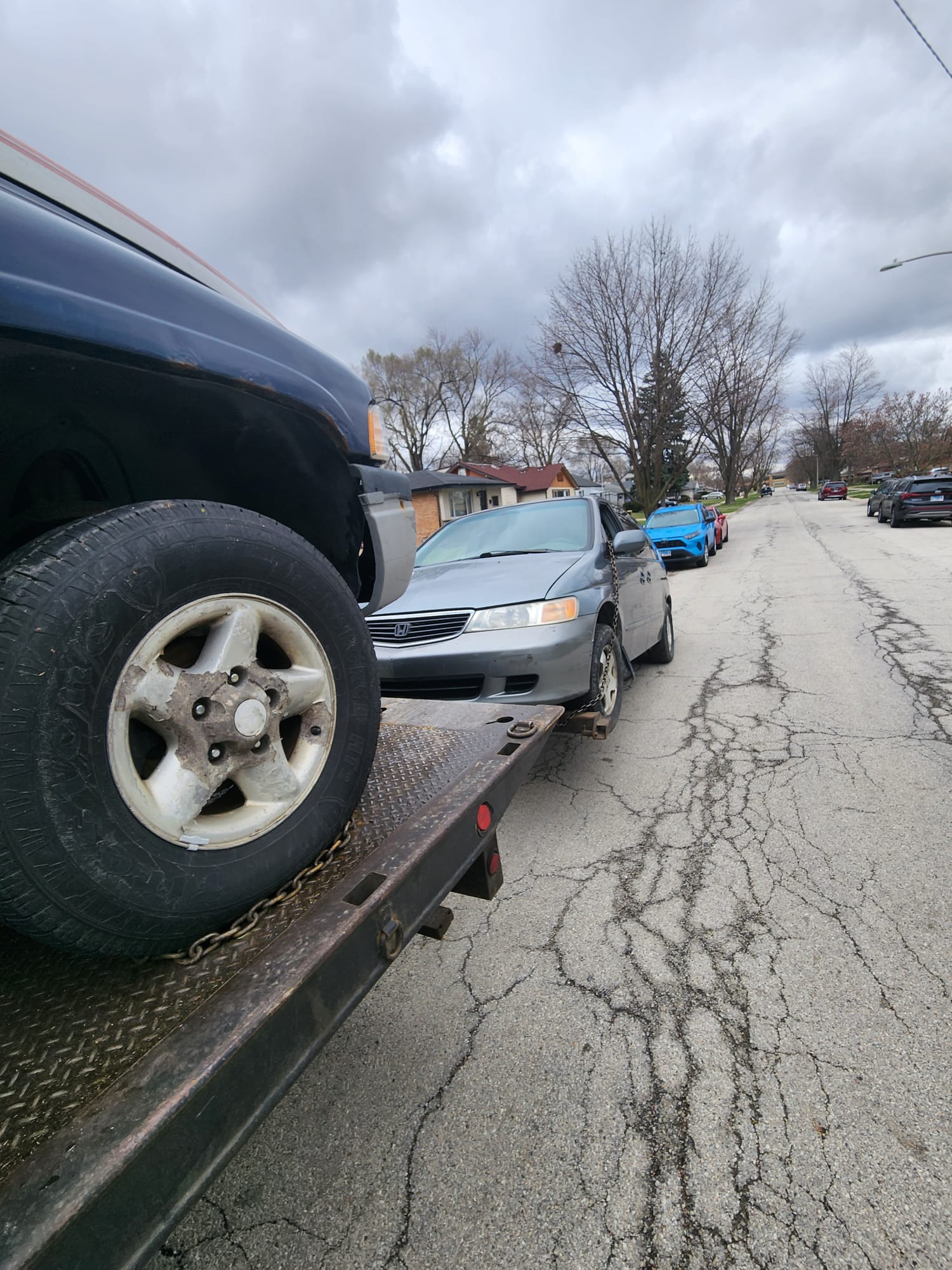 Honda Accord being winched onto the flatbed at the curb
