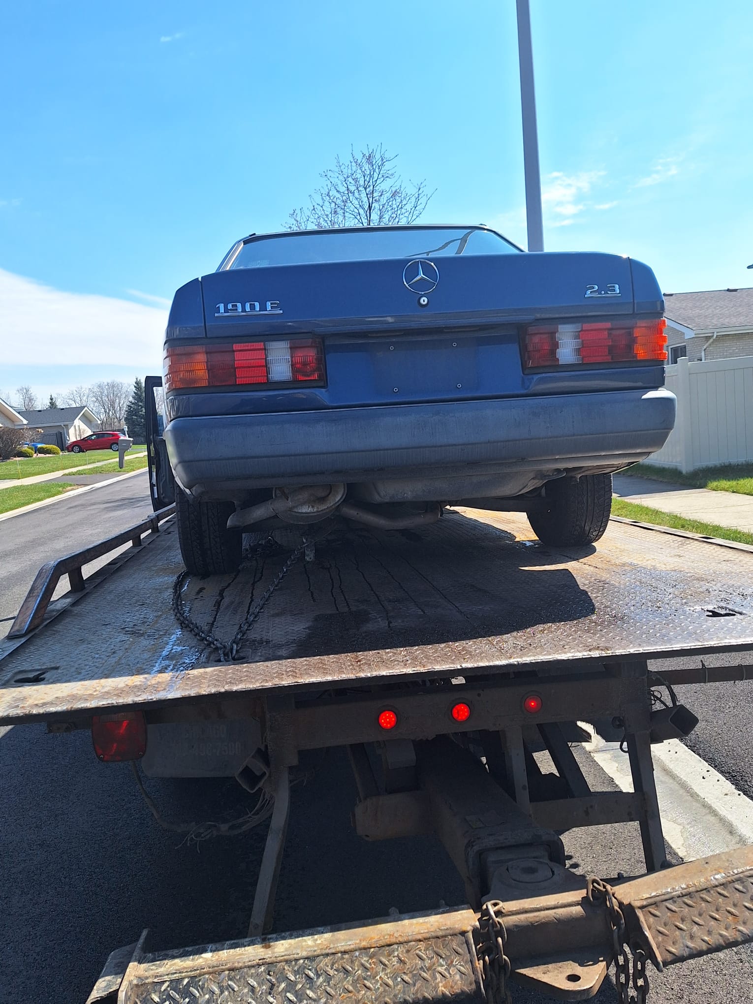 Mercedes 190E chained down on our flatbed on a Chicago-area street